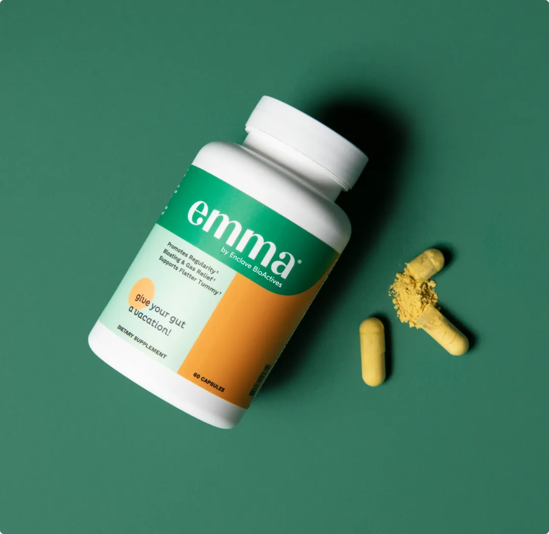 Two yellow Emma supplement capsules beside the bottle